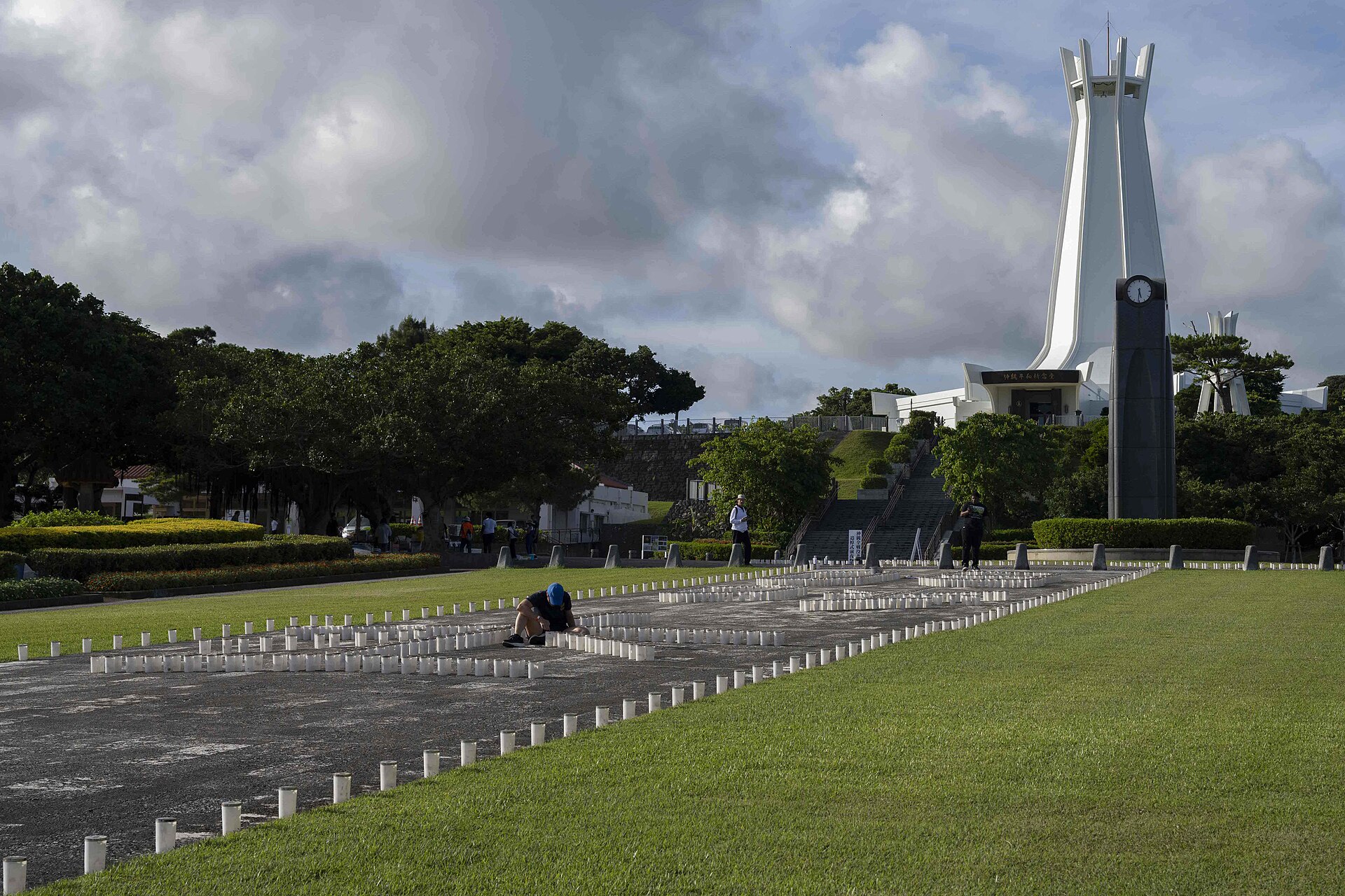 ITOMAN, Japan Hospital Corpsman 2nd Class Andrea Mayrose, from Salem, South Dakota, assigned to U.S. Naval Hospital Okinawa, helps light the more than 7,000 candles that illuminate the memorials walls and walk ways at Peace Memorial Park during a volunteer candle lighting event in Itoman, Okinawa, Japan, June 22, 2025. Held on the eve of Okinawa Memorial Day, the event marked the 80th anniversary of the 1945 Battle of Okinawa, honoring more than 200,000 lives lost and strengthening ties between the U.S. Navy and the local community. (U.S. Navy Photo by Mass Communication Specialist 2nd Class Zack Guth)